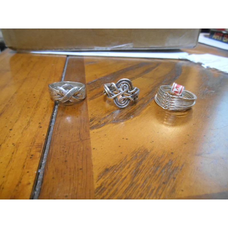 Four silver puzzle rings; 12, 8, 6, 3 bands