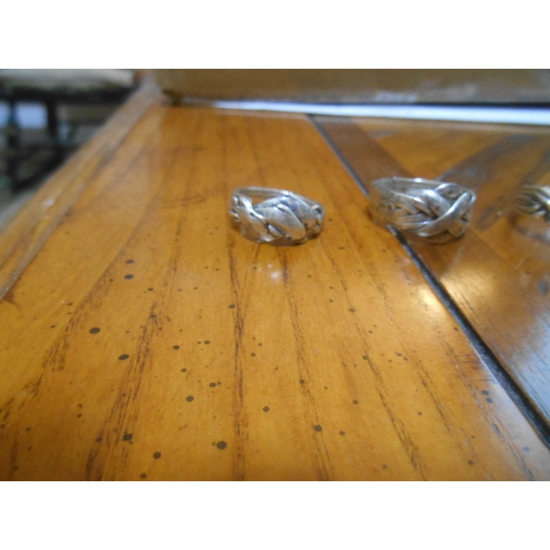 Four silver puzzle rings; 12, 8, 6, 3 bands