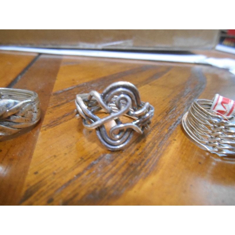 Four silver puzzle rings; 12, 8, 6, 3 bands
